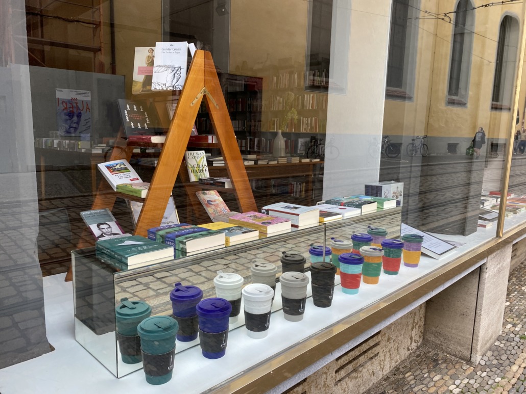 Schaufenster der Buchhandlung mit Büchern und mit ToGo Becher